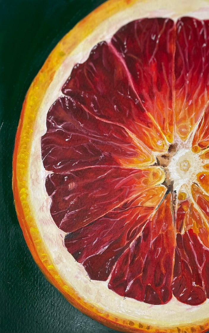 Nahaufnahme eines Ölgemäldes einer aufgeschnittenen Blutorange mit detaillierter Darstellung der Fruchtsegmente und der Schale vor grünem Hintergrund.