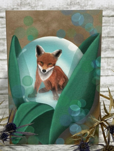 Fuchs sitzt in einer transparenten Kugel, die von großen grünen Blättern umgeben ist