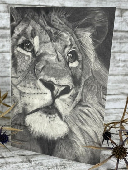 Schwarz-weiße Bleistiftzeichnung eines Löwenkopfs mit detaillierter Mähne und ausdrucksstarken Augen.