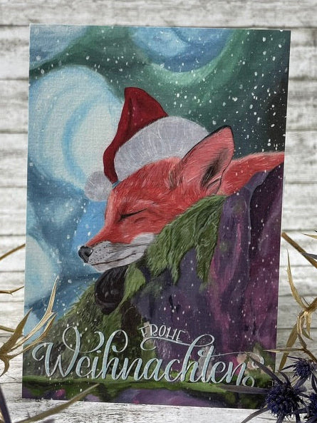 Weihnachtsfuchs Postkarte 10x15 cm, Acrylbild eines schlafenden Fuchses mit rotem Santa-Hut vor winterlicher Landschaft; sanfte Farbtöne in Blau, Grün und Lila.